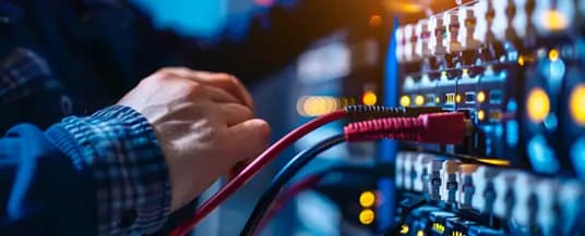 Two network engineers working together to configure server rack equipment inside a data center