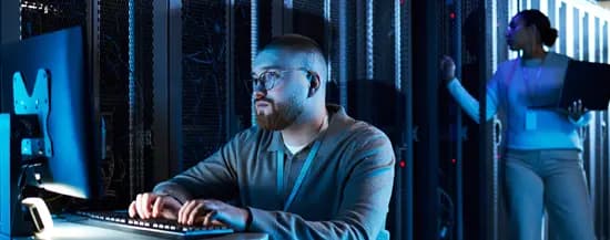 Network specialist checking server metrics on a tablet terminal inside a main distribution facility