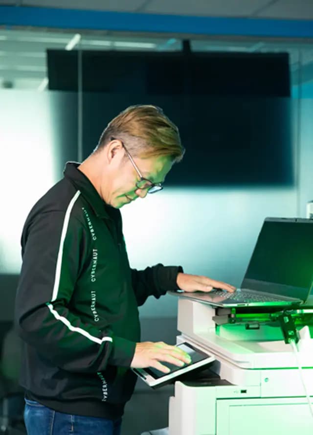 IT specialist setting up a digital tablet controller interface on an office printer scanner machine